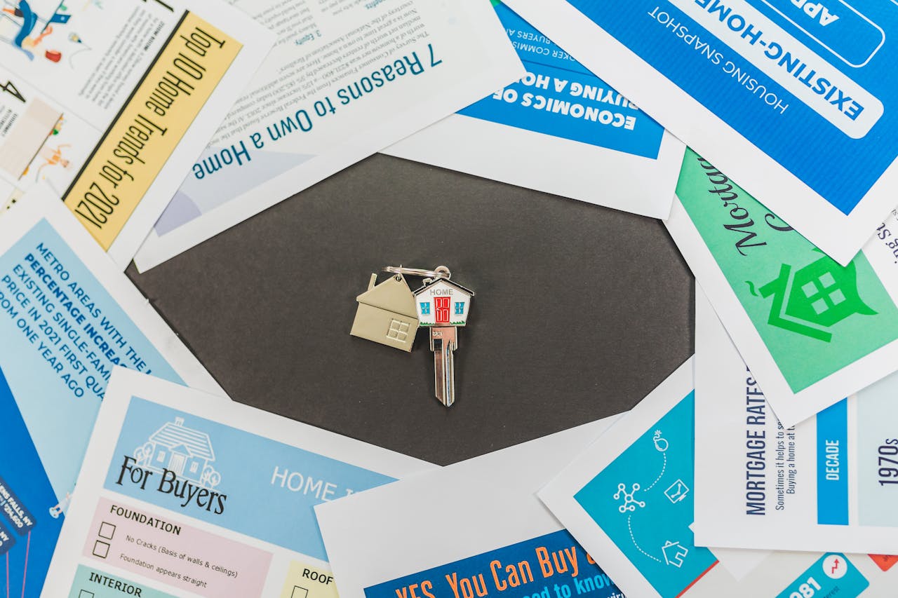 Overhead view of real estate brochures and house key, ideal for marketing.